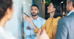 Coworkers looking at information on a whiteboard.