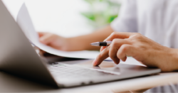 Closeup image of a higher education leader working on a laptop, representing the importance of reviewing upcoming federal rule changes that will affect student cash flow at colleges and universities.