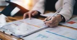 Financial professional reviewing charts and reports on an office desk, illustrating the concept of higher education trends